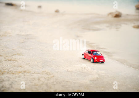 Tel Aviv, Israele - 10 Aprile 2017: auto rossa miniatura sulla spiaggia in soft focus. Foto Stock