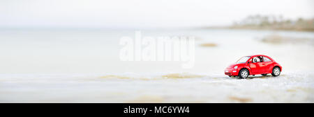 Tel Aviv, Israele - 10 Aprile 2017: auto rossa miniatura sulla spiaggia in soft focus. Foto Stock