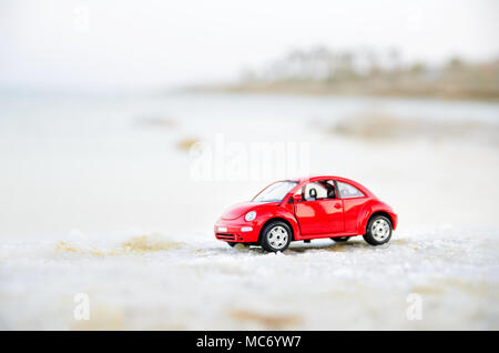 Tel Aviv, Israele - 10 Aprile 2017: auto rossa miniatura sulla spiaggia in soft focus. Foto Stock