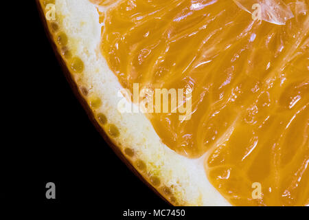 Macro di fetta di colore arancione su sfondo nero Foto Stock