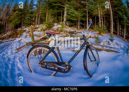 SVOLVAER, isole Lofoten, Norvegia - 10 Aprile 2018: veduta esterna del vecchio arrugginito-biciclette abbandonate nella neve in attesa per il periodo estivo per venire e riutilizzato in Norvegia Foto Stock