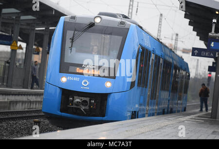 13 aprile 2018, Germania, Wiesbaden: una cella a combustibile alimentata a treno communter del costruttore francese Alstrom parte dalla stazione ferroviaria. Il trasporto regionale associazione 'Rhein-Main-Verkehrsverbund' vuole sostituire il treno diesel motori che sono stati la manutenzione di quattro non elettrificate linee secondarie nella regione Taunus. Foto: Arne Dedert/dpa Foto Stock