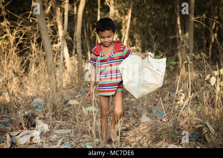 Un giovane ragazzo Rohingya passeggiate attraverso un bosco di spazzatura in Kutupalong Refugee Camp. Ora ci sono circa 600.000 rifugiati Rohingyas in Kutupalong campo profughi del sud del Bangladesh. Mentre i preparativi sono ormai essendo realizzato per la stagione dei monsoni che si sta avvicinando velocemente, molte ONG hanno lasciato lasciando molto lavoro da fare per rendere le loro insufficienze. Foto Stock