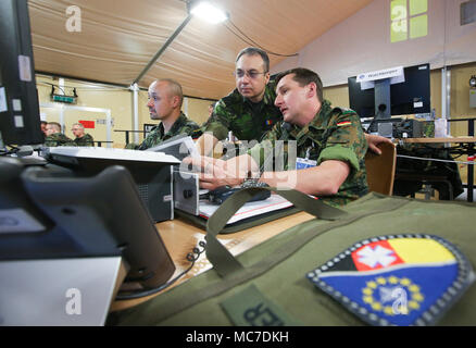 13 aprile 2018, Germania, Stetten am kalten Markt: Sergente Thomas Maier (l-r), il tenente colonnello Dan Simescu dalla Romania e il tenente colonnello Karsten Dyba stanno lavorando nella telefonia mobile centro operativo comune della multinazionale Kommando Fuehrung operativa (multinazionale sede congiunta) che è impostato sulla formazione militare terra 'Heuberg' in Stetten am kalten Markt. Il commando è inizio preparatiuon per la certificazione della NATO per la distribuzione in aree di conflitto. Il test finale si svolge alla fine di maggio in una scala grande esercitazione militare chiamato "Trident Jaguar' Photo: Thomas Warnack Foto Stock