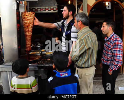 Ghouta orientale, Siria. Xiii Apr, 2018. Un uomo si prepara Shawarma in Kafar Batna città Ghouta Orientale, campagna di Damasco, Siria, il 13 aprile 2018. L'esercito siriano ha riacquistato Kafar Batna e in altre città Ghouta orientale alla fine del mese scorso e le persone che hanno sofferto per anni di assedio cominciato ottenere la loro vita all'indietro. Credito: Ammar Safarjalani/Xinhua/Alamy Live News Foto Stock