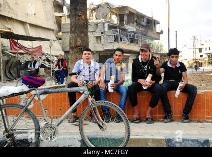 Ghouta orientale, Siria. Xiii Apr, 2018. La gente mangia Shawarma in Kafar Batna città Ghouta Orientale, campagna di Damasco, Siria, il 13 aprile 2018. L'esercito siriano ha riacquistato Kafar Batna e in altre città Ghouta orientale alla fine del mese scorso e le persone che hanno sofferto per anni di assedio cominciato ottenere la loro vita all'indietro. Credito: Ammar Safarjalani/Xinhua/Alamy Live News Foto Stock