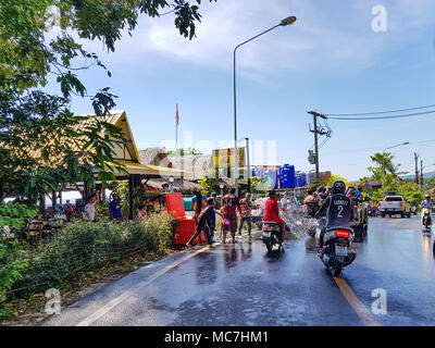 Phuket, Tailandia - 13 Aprile 2018: l'uomo versare acqua sul driver moto celebrare tailandese tradizionale nuovo anno - Songkran Festival. Credito: Anna Moskvina/Alamy Live News Foto Stock