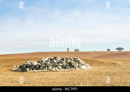 Una grande area del campo arato con un mucchio di pietre in Alentejo, Portogallo Foto Stock