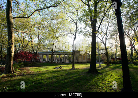 Una donna si appoggia nell'erba a Monsignor McGolrick Park, a Brooklyn, New York, nel maggio 2013. Foto Stock