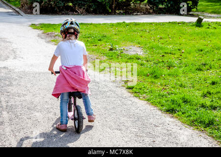 Bambina equitazione sulla sua bicicletta rosa. Foto Stock