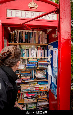 Hinxton, Cambridgeshire. Una cabina telefonica è ridefinito come una biblioteca. Foto Stock