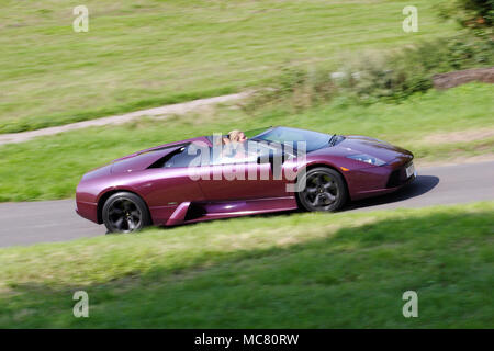 Profilo (vista laterale) di un viola Lamborghini Murcielago Roadster (open top o convertibili) guida veloce. Foto Stock