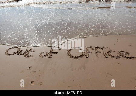 Fuori ufficio scritto nella sabbia Foto Stock