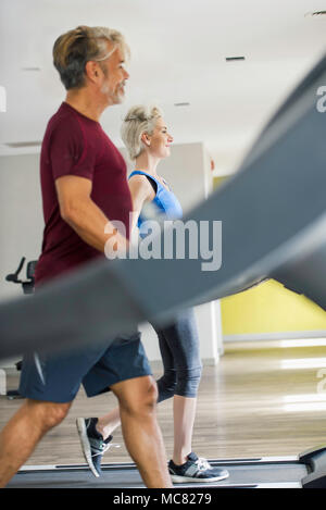 L uomo e la donna che esercitano su tapis roulant Foto Stock