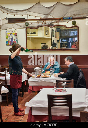 San Sebastian, Spagna - 28 Marzo 2018. Cameriera serve Txakoli ai clienti. Un tipico vino con una leggera la carbonizzazione prodotte nel Paese Basco. W Foto Stock