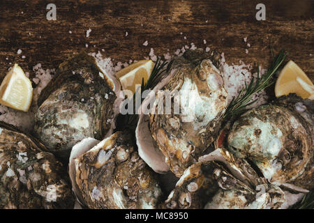 Open shell oyster con limone e sale su una tavola di legno