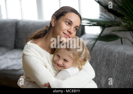 Amorevole Madre single abbracciando carino piccola figlia che mostra amore care support, donna felice abbracciando la ragazza in età prescolare a casa, mamma e bambino sincero re caldo Foto Stock