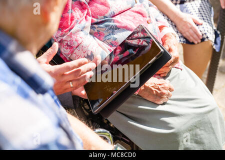 Old womans è avente dispositivo indossabile smart guardare in casa di cura Casa di pensionamento. Medico spiegare tecnologie Foto Stock