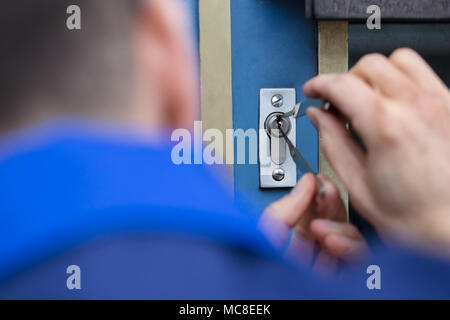 Close-up di un giovane uomo di apertura porta con Lockpicker Foto Stock