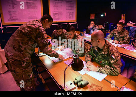 Stati Uniti Il personale dell'esercito Sgt. Modificare L. McGraw, un paracadutista assegnato all'173rd Airborne Brigade incarica l'Esercito Italiano paracadutisti assegnato al reggimento "Savoia Cavalleria" Folgore Brigata Grosseto, durante il corso di formazione utilizzando la funzione Chiamata per incendio Trainer system (principale) alla Caserma Ederle Vicenza, Italia, 27 marzo 2018. I paracadutisti italiani utilizzare U.S. RTSD esercito sud attrezzatura per migliorare le relazioni bilaterali e per espandere i livelli di cooperazione e la capacità del personale coinvolto nelle operazioni congiunte. Foto Stock