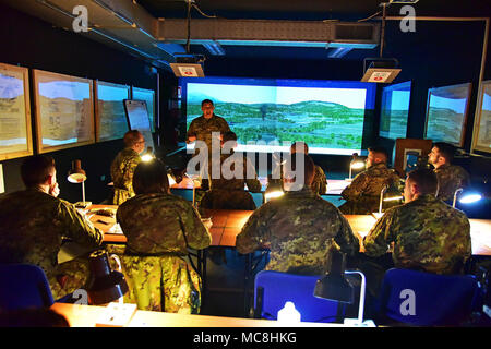 Stati Uniti Il personale dell'esercito Sgt. Modificare L. McGraw, un paracadutista assegnato all'173rd Airborne Brigade incarica l'Esercito Italiano paracadutisti assegnato al reggimento "Savoia Cavalleria" Folgore Brigata Grosseto, durante il corso di formazione utilizzando la funzione Chiamata per incendio Trainer system (principale) alla Caserma Ederle Vicenza, Italia, 27 marzo 2018. I paracadutisti italiani utilizzare U.S. RTSD esercito sud attrezzatura per migliorare le relazioni bilaterali e per espandere i livelli di cooperazione e la capacità del personale coinvolto nelle operazioni congiunte. Foto Stock