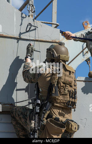 Un U.S. Marine assegnato al Raid marittimo forza (MRF), 26 Marine Expeditionary Unit (MEU), sale una scala di speleologia durante la rigida-scafo gommone inserimento formazione presso la base navale di Souda Bay, Creta, Grecia, 15 marzo 2018. La NATO di interdizione marittima Operations Training Center ha ospitato il MRF la formazione come parte di un due settimane di corso progettato per insegnare di interdizione marittima tecniche per la NATO nazioni partner. Foto Stock