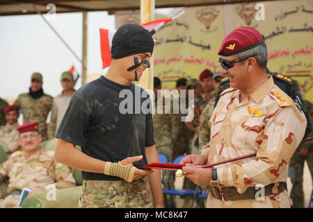 Un iracheno gli stati con il battaglione del deserto è presentato un premio dal suo leader durante una precisione di tiro di base formazione cerimonia di laurea al Taqaddum, Iraq, Marzo 29, 2018. Questa formazione fa parte del complesso di Combined Joint Task Force - Funzionamento inerenti risolvere potenziata la capacità dei partner di missione che si concentra sul miglioramento delle funzionalità di sicurezza all'interno della nazione. Foto Stock