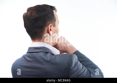 Vista posteriore di pensare l'uomo. L'uomo con la mano sotto il mento Foto Stock