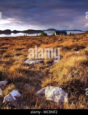 Un inverno vista attraverso la Wester Ross costa guardando verso l'estate isole come il sole tramonta. Foto Stock