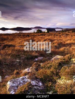 Un inverno vista attraverso la Wester Ross costa guardando verso l'estate isole come il sole tramonta. Foto Stock