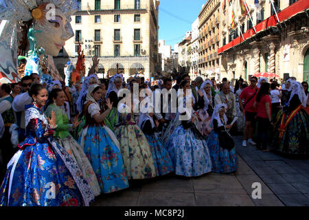 Tradizionalmente vestiti persone all'Hogueras de Festival di San Juan di Alicante in Spagna, la pubblicazione per una foto di fronte a un enorme polena Foto Stock