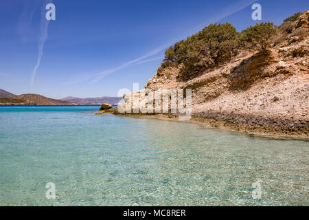 Colorate le onde del mare presso la costa rocciosa nella parte orientale dell'isola. Offuscata dal moto dell'acqua. Giornata di sole a Creta. Foto Stock