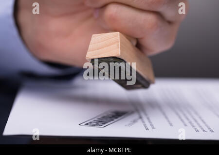 Close-up di un imprenditore mano del documento di timbratura Foto Stock