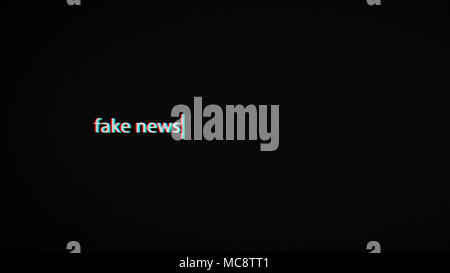 Fake news il testo allo schermo del laptop con effetto di glitch e sfondo nero Foto Stock