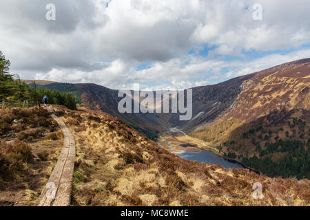 Gli escursionisti a piedi salendo in prova la cresta Spinc sulla spettacolare Glendalough e valli Glenealo nel Parco Nazionale di Wicklow Mountains Foto Stock