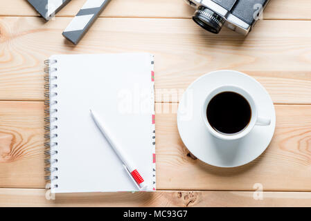 Un notebook su molle dal di sopra, una tazza di caffè e oggetti per le riprese di un film Foto Stock