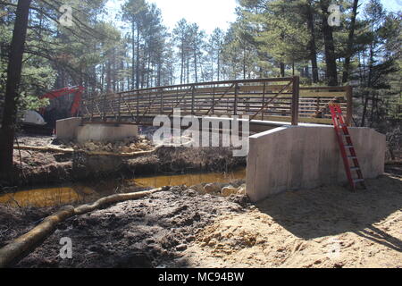 Un ponte pedonale essendo costruito da NuGen Johnson LLC del Sussex, Wis., è mostrato il 28 marzo 2018, accanto alla La Crosse River e Vista Pineta Campeggio a Fort McCoy, Wis. un nuovo ponte viene collocata nella stessa area in cui un ponte lavato fuori diversi anni fa e che sta per essere una parte del sistema di pista in vista pineta Area ricreativa al momento dell'installazione. (U.S. Foto dell'esercito da Scott T. Sturkol, Ufficio per gli affari pubblici, Fort McCoy, Wis.) Foto Stock