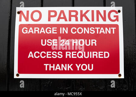 Nessun parcheggio garage in uso costante accesso 24 ore segno richiesto. La ringrazio. Rosso e bianco segno isolato su sfondo nero. Foto Stock