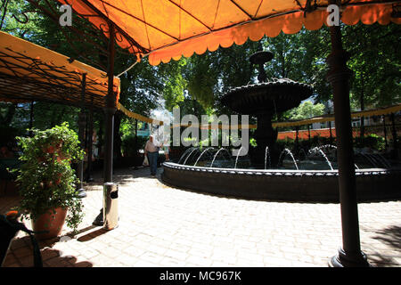 Un adorabile caffè all'interno di un parco vicino al Golden Gate a Kyiv, dove il popolo ucraino e godetevi la prima estate-come sunray dopo un inverno duro Foto Stock