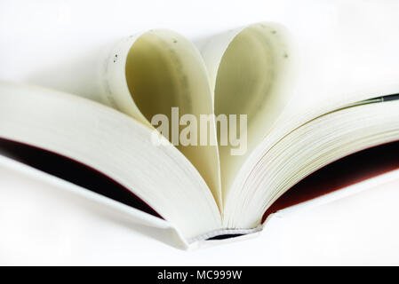 Forma di cuore dalla pagina del libro su sfondo bianco. Copia dello spazio. Il concetto di amore Foto Stock