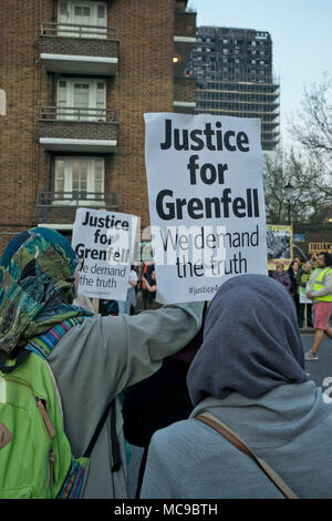 Veglia silenziosa da superstiti e i vicini del Grenfell Torre blocco alloggiamento disastro incendio a piedi passato la sua bruciato resti in Londra, Regno Unito Foto Stock