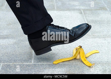 Imprenditore stepping sulla buccia di banana Foto Stock