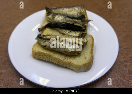 Sandwich di spratti e caviale, cipolla, su uno sfondo di legno. Vista dall'alto. Spazio di copia Foto Stock