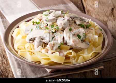 Fettuccine con tradizionale italiano cremosa salsa alla boscaiola closeup su una piastra su un piano orizzontale. Foto Stock