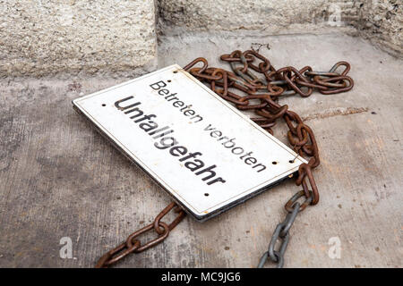 Segno giacente sul piano con parole tedesche senza sconfinamenti di pericolo di incidenti Foto Stock
