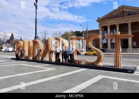 I turisti a scattare foto in Piazza degli Eroi in Budapest l'installazione. Ungheria. Hot soleggiata giornata di primavera, aprile 2018. Foto Stock