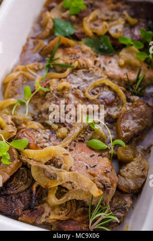 Tritare la carne di maiale al forno con mele, erbe aglio e cipolla Foto Stock