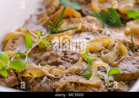 Tritare la carne di maiale al forno con mele, erbe aglio e cipolla Foto Stock