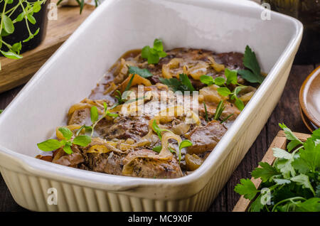 Tritare la carne di maiale al forno con mele, erbe aglio e cipolla Foto Stock