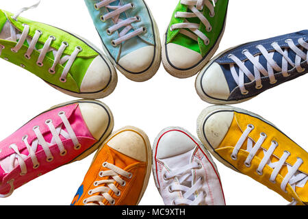 Scarpe colorate su sfondo bianco. Raffreddare la gioventù bianco colorato giallo verde nero blu arancione scarpe palestra in piedi in cerchio su sfondo bianco con co Foto Stock